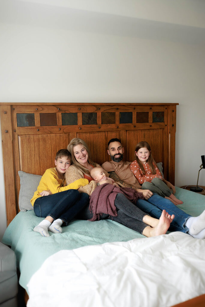 cuddled family photo on mom and dads bed