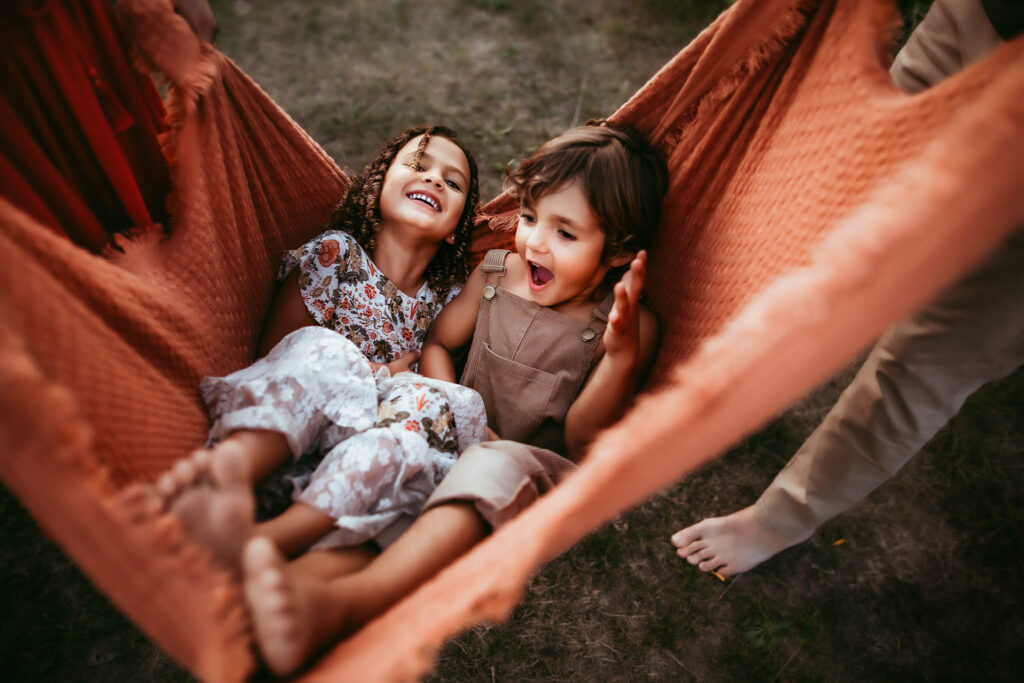 twins swinging in blanket during family photoshoot