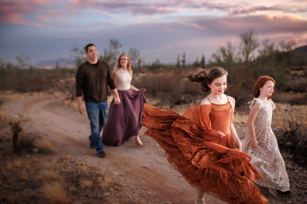 family happily running through desert during lifestyle photography session in phoenix