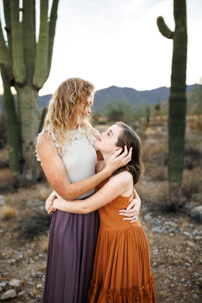 mother and daughter looking into each others eyes while embraced in a hug in the phoenix desert