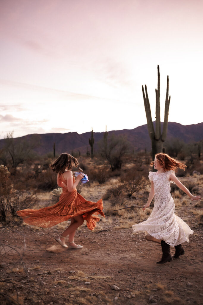 girls twirling in dresses at dusk during lifestyle family photos