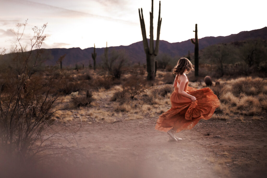 girl dancing while kicking up dust in desert lifestyle family photography