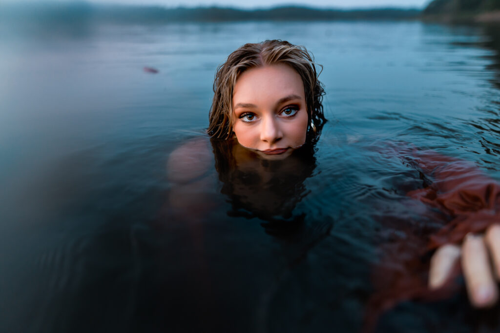 water shoot with girl nearly submerged and reaching toward the camera