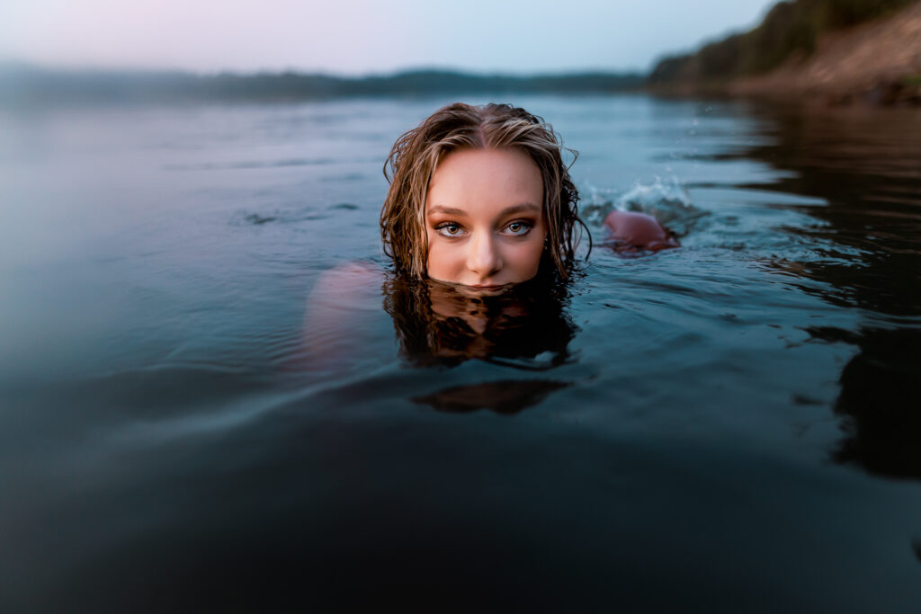 senior pictures in the water with girl nearly fully submerged in lake