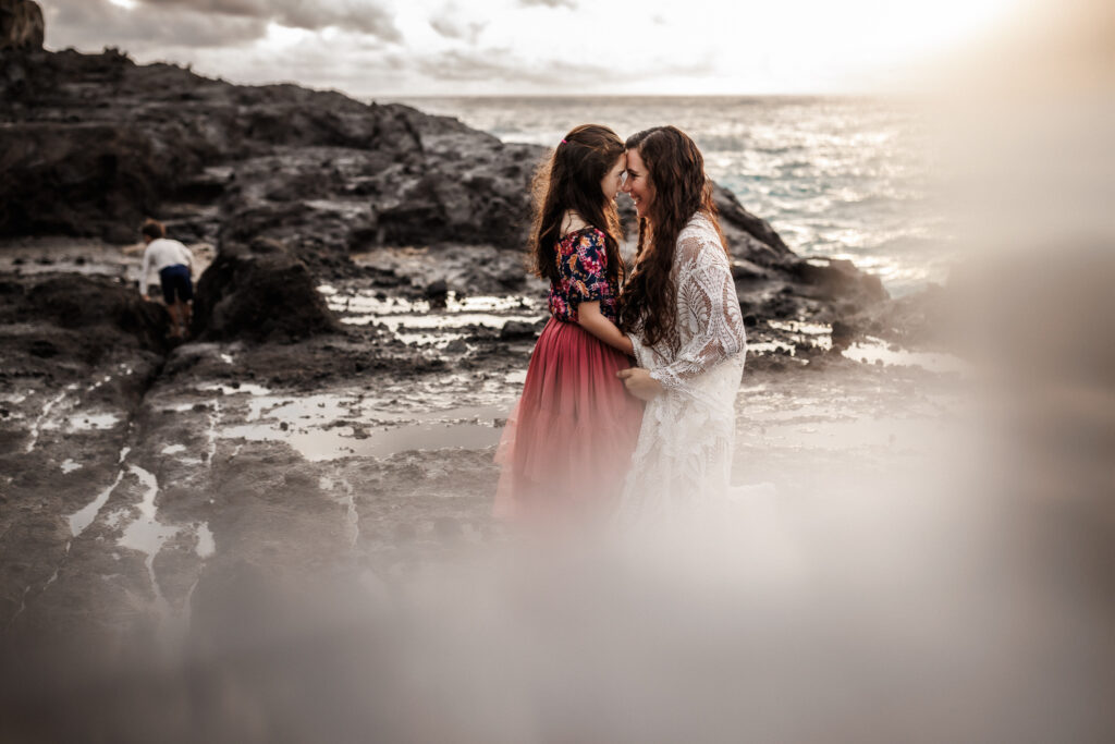 mom and daughter giggling as they are forehead to forehead during photoshoot behind the scenes