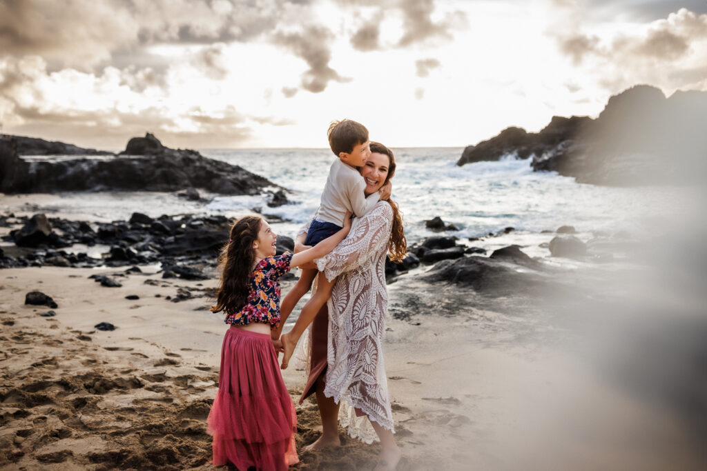 family hug on the sandy beach of oahu