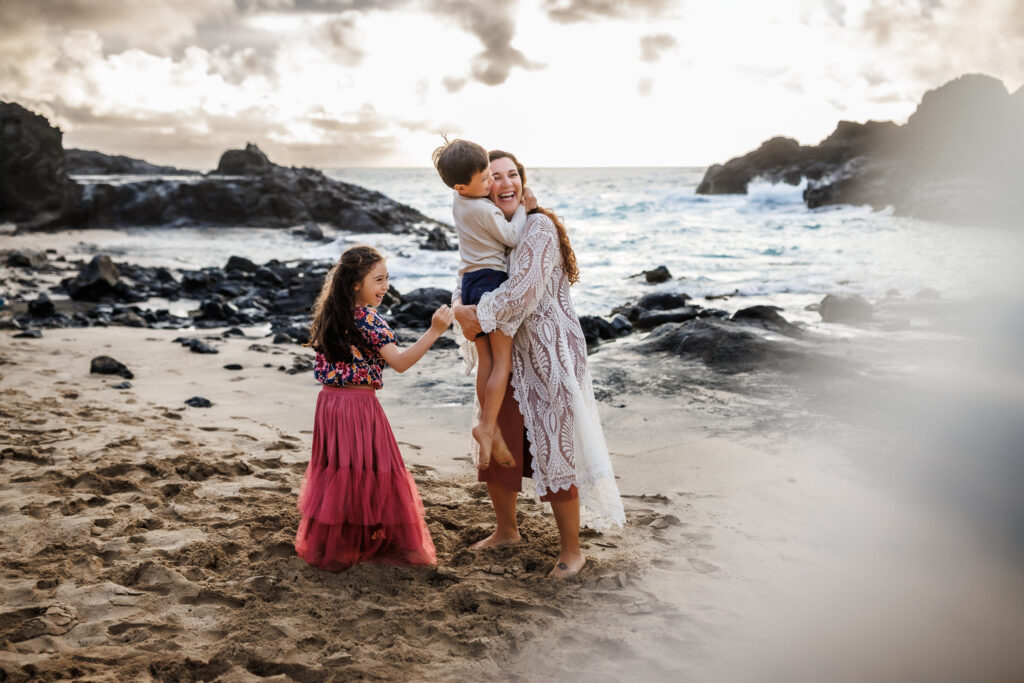 family laughing on the beach of oahu during photoshoot