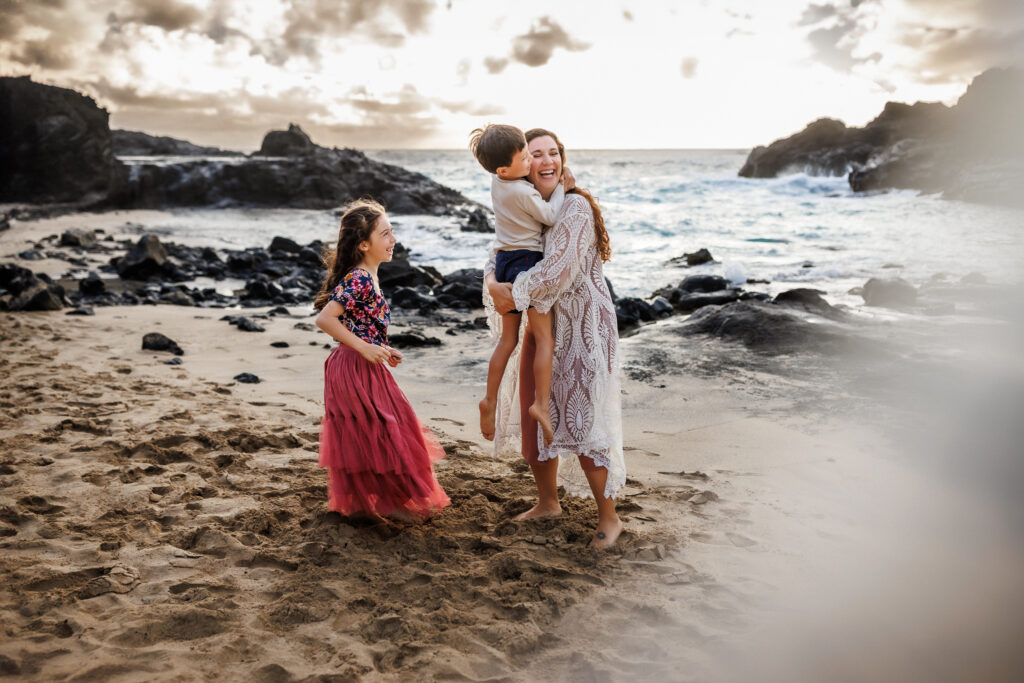 family hugging little brother during behind the scenes of photoshoot on oahu