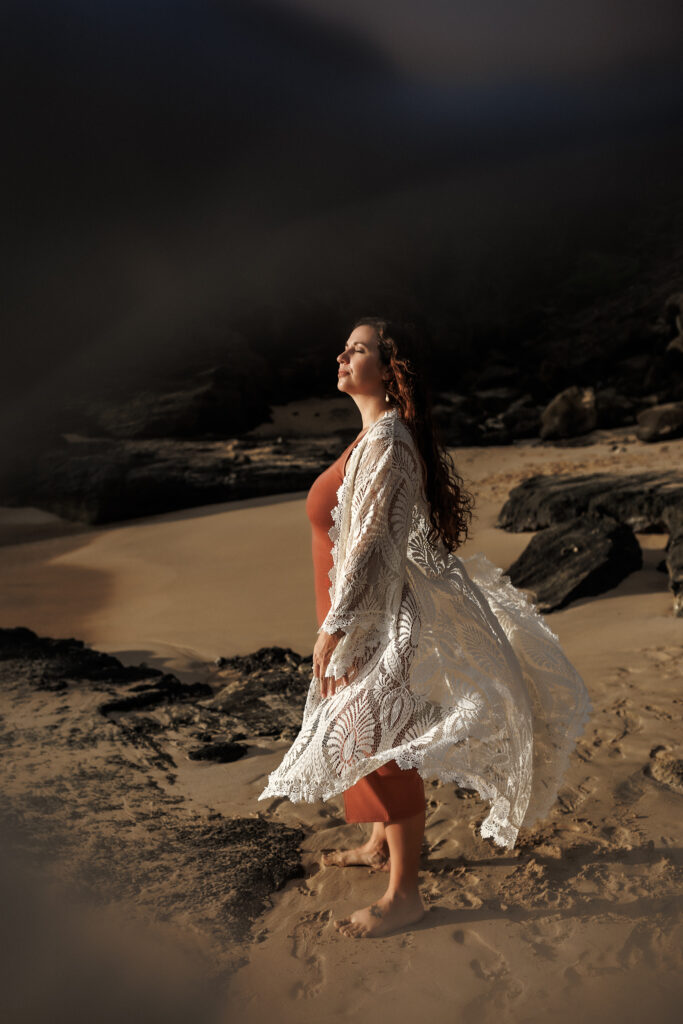 moody image of mom on the beach with flowing duster over dress