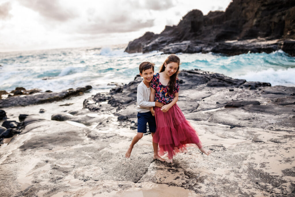 children playing on coast of hawaii during family photoshoot